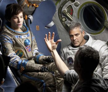 Sandra Bullock e George Clooney col regista Alfonso Cuaron che spiega come devono recitare