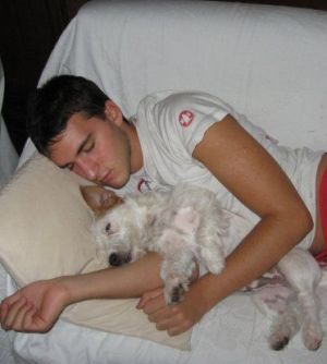 Marco Bonamino in una immagine tratta dal suo profilo facebook che dorme insieme al suo cane 