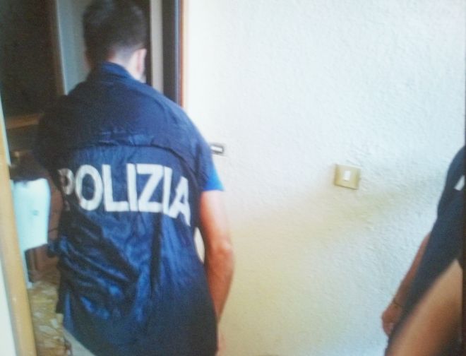 I poliziotti mentre mettono i sigilli all'ingresso 