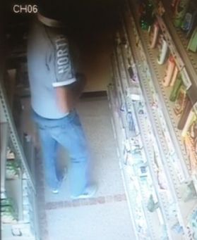 Uno dei ladri mentre ruba al supermenrcato