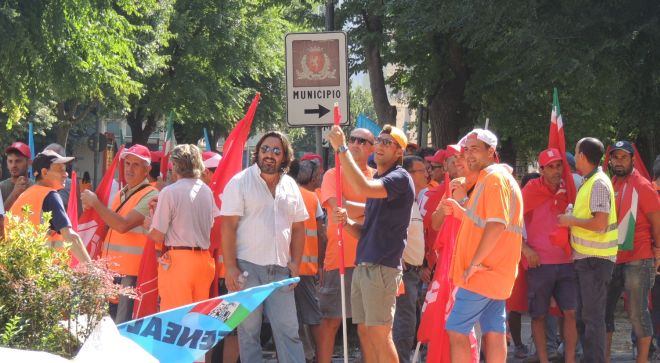 lavoratori in attesa fuori dal Comune mentre si svolge l'incontro