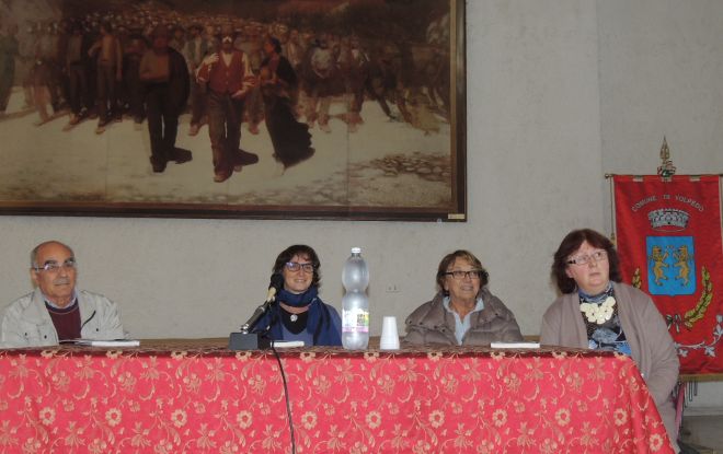la presentazione con alle spalle il una riproduzioone del famoso quiadro