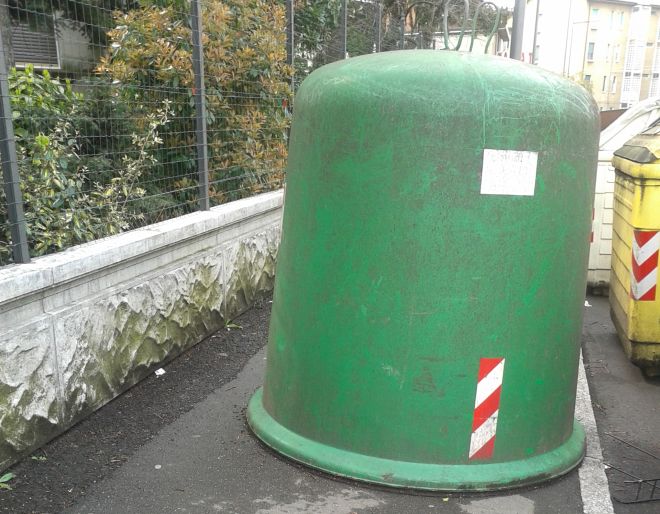 Largo Europa a Tortona: il marciapiede occupato dalla campana per il vetro, passare è impossibile