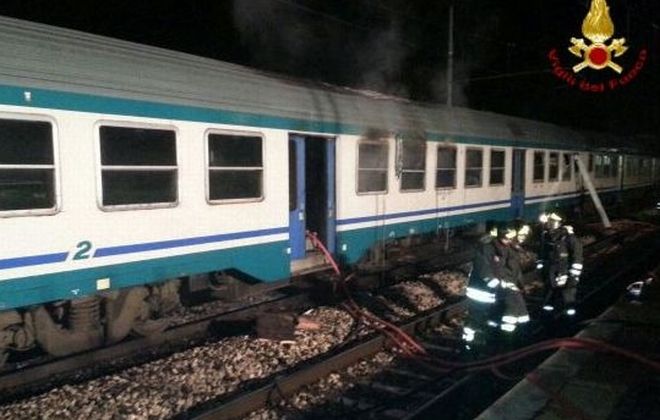 Tre carrozze in fiamme di un treno fermo alla stazione di Alessandria