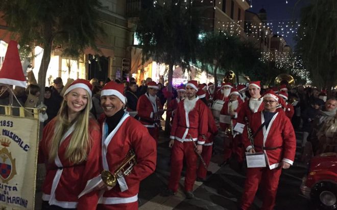 Tante persone ad applaudire la Banda musicale di Diano Marina in concerto per le vie della città. Le immagini