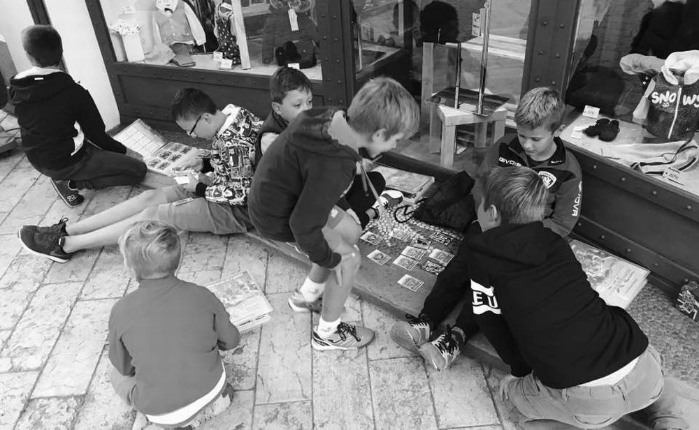 Diano Marina isola felice e d’altri tempi: i bambini giocano contenti in strada davanti ad un negozio