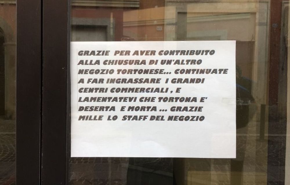 Chiude un negozio a Tortona e chi lo gestiva fa polemica con questo messaggio sul vetro